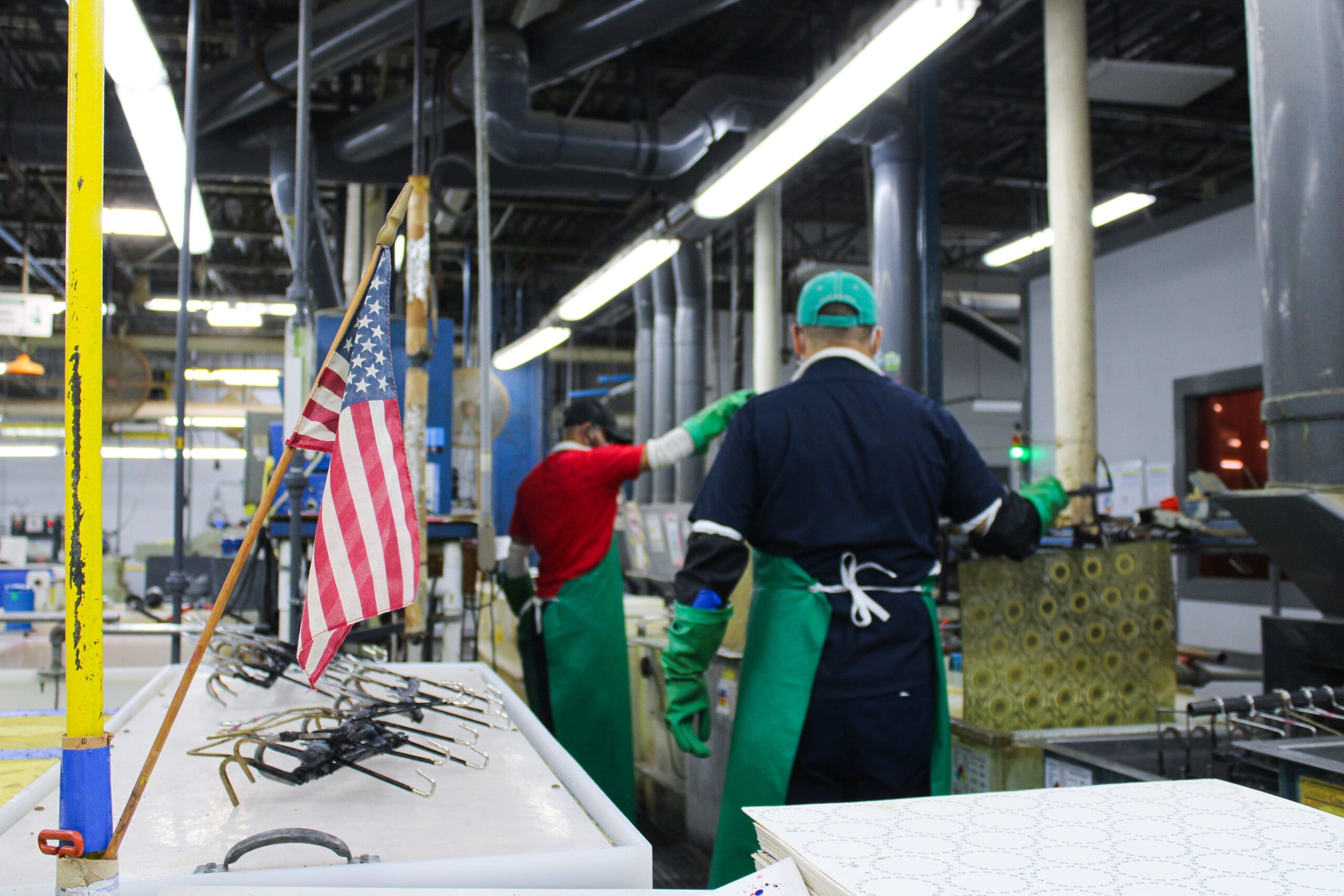 Beacon Design production employees working with American Flag in the foreground.