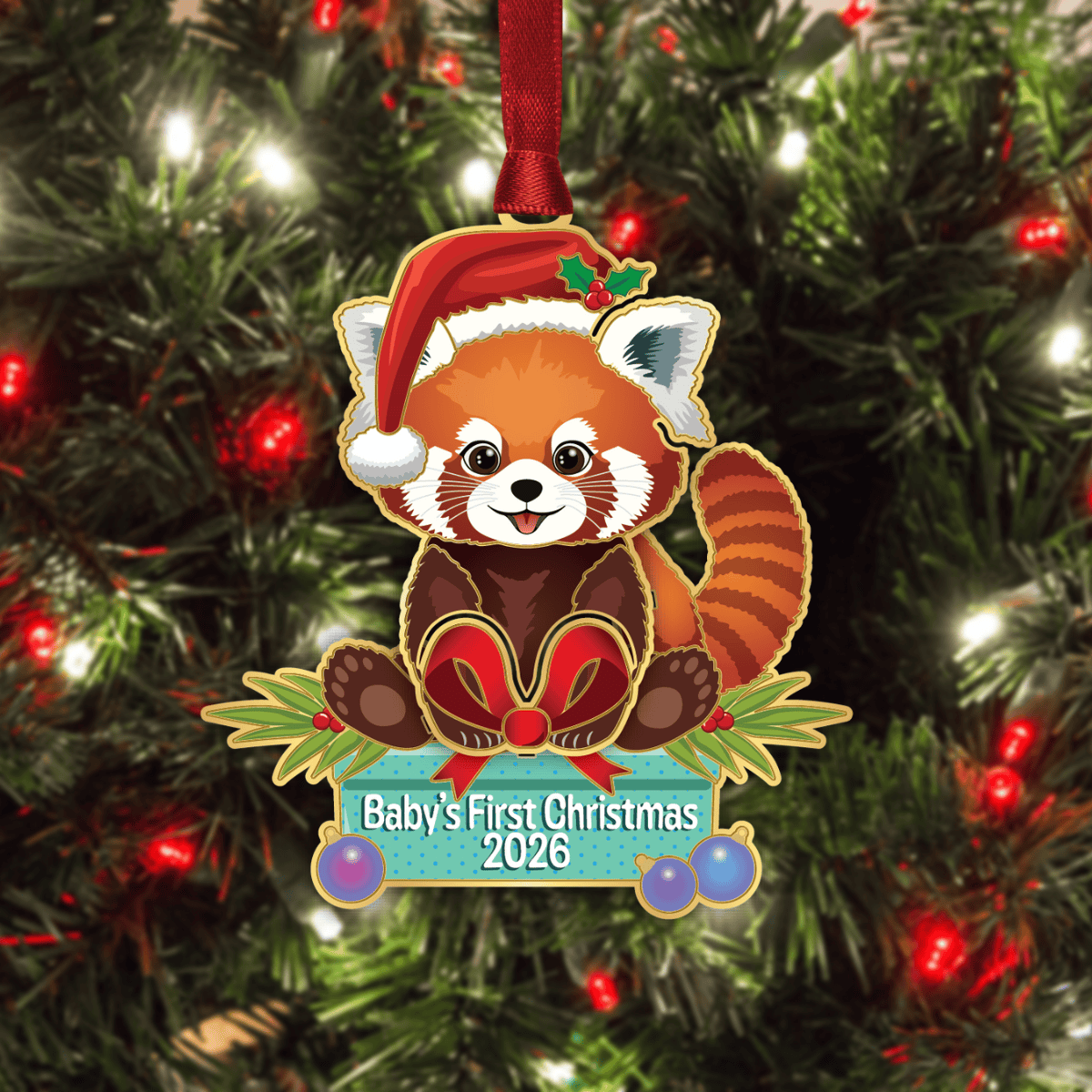 Ornament featuring a red panda wearing a Santa hat with the message “Baby’s First Christmas 2026,” displayed on a decorated Christmas tree