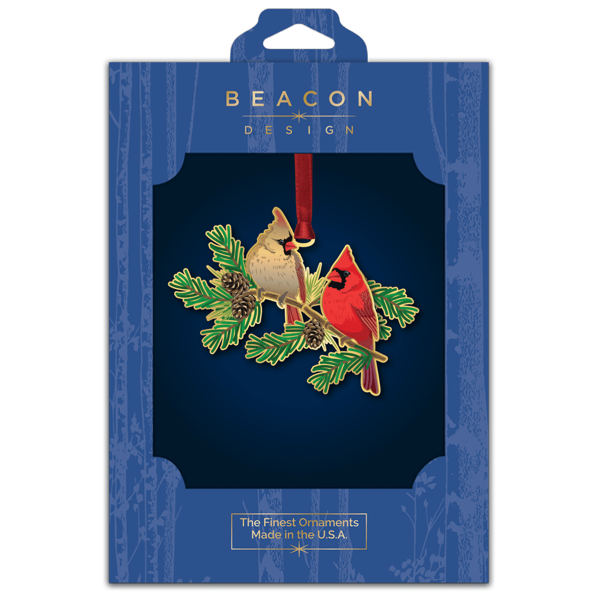 Ornament featuring a pair of northern cardinals perched on evergreen branches with pinecones, displayed in Beacon Design retail packaging