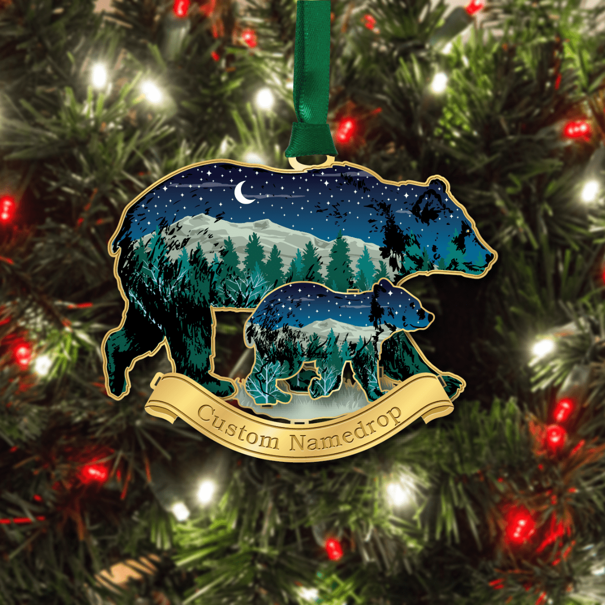 Custom namedrop ornament featuring a bear and cub silhouette with a mountain and forest night scene displayed on a decorated Christmas tree