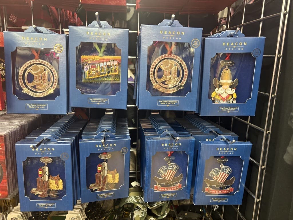 Display of Beacon Design ornament boxes featuring Nashville-themed designs arranged on a retail rack at Legends Gift Shop.